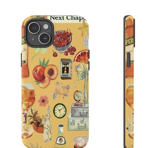 May include: A yellow phone case featuring a collage of illustrations including peaches, cherries, a scooter, a clock, and a glass of orange-colored beverage. The text "Next Chap" is visible at the top.
