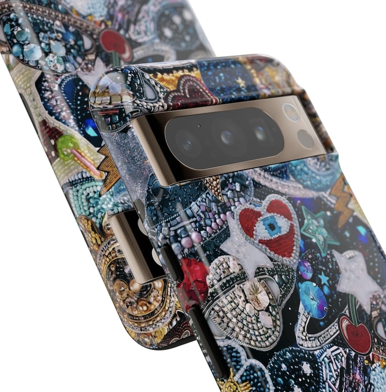 May include: A black phone case with a colourful, glittery design featuring hearts, stars, and other embellishments. The case has a gold trim and a camera lens cover.