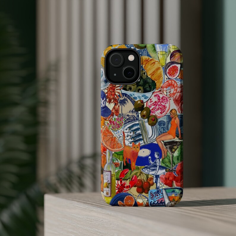 May include: A colorful phone case with a collage of images, including a cat, fish, fruit, and a woman in a swimsuit. The case has a blue and white background with a red and yellow accent. The text "ORIGINA" is visible on the bottom of the case.