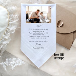 May include: White handkerchief with a photo of a father and daughter, a handwritten message that reads "Dad. Today a bride, tomorrow a wife, always your little girl. Thank you for walking by my side today and always. Thank you for being the best dad anyone could ever ask for. Love you to the moon and back, Jessica August 26th, 2023."