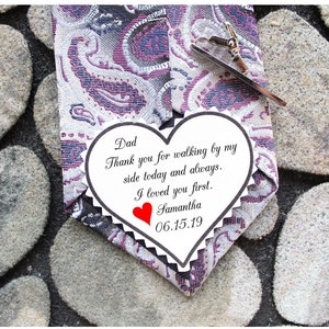 May include: A white heart-shaped card with a message for a father. The card says "Dad, Thank you for walking by my side today and always. I loved you first. Samantha 06.15.19".