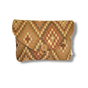 May include: A rectangular clutch with a woven pattern in shades of brown, orange, and green. The flap closure is secured with a round, wooden button. The clutch is designed with a geometric pattern.