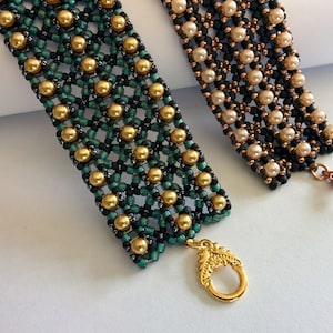 May include: Two beaded bracelets with gold and black beads, and one with copper and black beads. Both bracelets have gold clasps.