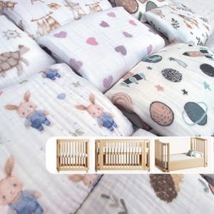 May include: A collection of baby bedding and a wooden crib. The bedding features various patterns, including hearts, bunnies, and space-themed designs. The crib is made of light-colored wood and has a simple, modern design.