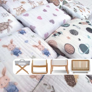 May include: A collection of white muslin swaddles with various patterns, including bunnies, hearts, and planets. The swaddles are displayed on a white surface with three different baby cribs in the background.
