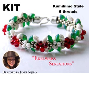 May include: A kit for making a beaded bracelet in a Kumihimo style with 6 threads. The bracelet features white, red, and green beads in a floral pattern. The kit is called "Edelweiss Sensations" and is designed by Janet Nijman.