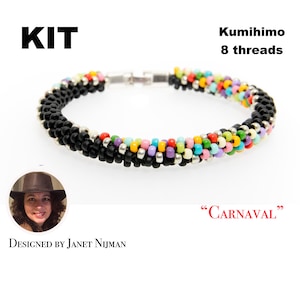 May include: A Kumihimo bracelet kit with 8 threads. The bracelet has a black beaded design with a section of colourful beads in red, purple, pink, green, and blue. The word "KIT" is in bold black letters. Designed by Janet Nijman.