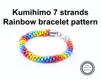 May include: Rainbow colored Kumihimo bracelet pattern with 7 strands. The bracelet is made with small beads and has a silver clasp. The text "Kumihimo 7 strands Rainbow bracelet pattern By Janet Nijman" is visible in the image.