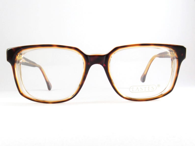 May include: Vintage eyeglasses with a tortoiseshell pattern frame. The rectangular frames have a dark brown color with a lighter brown and clear rim. The lenses are clear, and the temples are a light brown color.