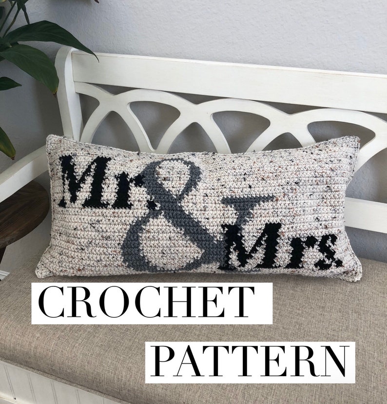 May include: Crochet pattern for a pillow with the words "Mr. & Mrs." in black and gray on a white background.