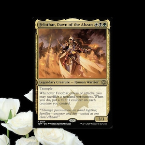 May include: A Magic: The Gathering card featuring Felothar, Dawn of the Abzan. The card has a gold and black border with an illustration of a warrior in armor. Text includes "Legendary Creature - Human Warrior" and game instructions. The card is 3/3.
