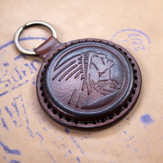 454 favorites don't lie — a handmade leather key fob stamped with a vintage Indian Head motif that feels like a relic from a cool old general store.