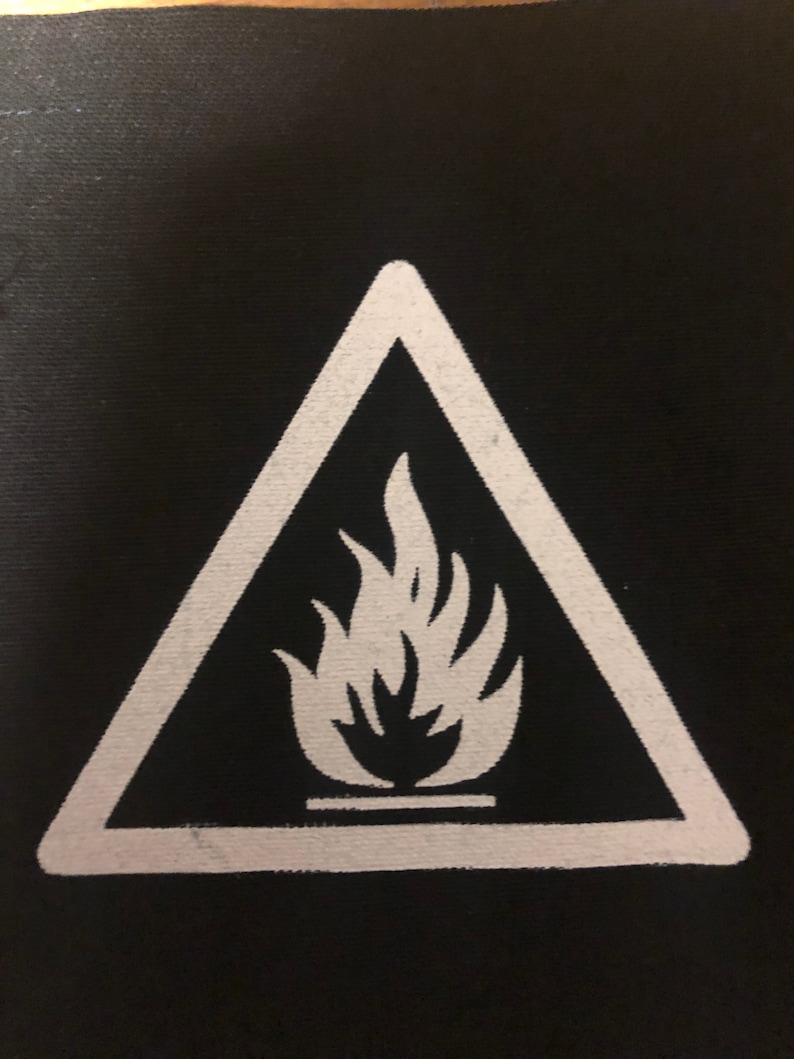 May include: White triangle warning sign with a white flame inside on a black background.