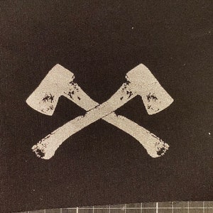 May include: A black fabric patch with two white crossed axes.