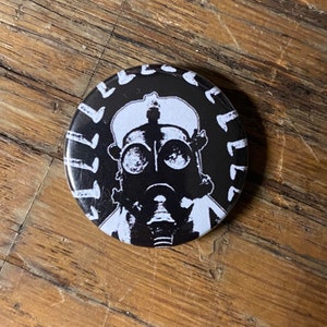 Gasmask haloed by nails - 1” pin