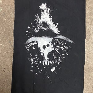 May include: Black and white patch with a skull design and the words "Freedom" and "Fire" printed on it.