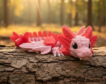 Juguete antiestrés articulado con forma de ajolote y dragón, impreso en 3D para escritorio.
