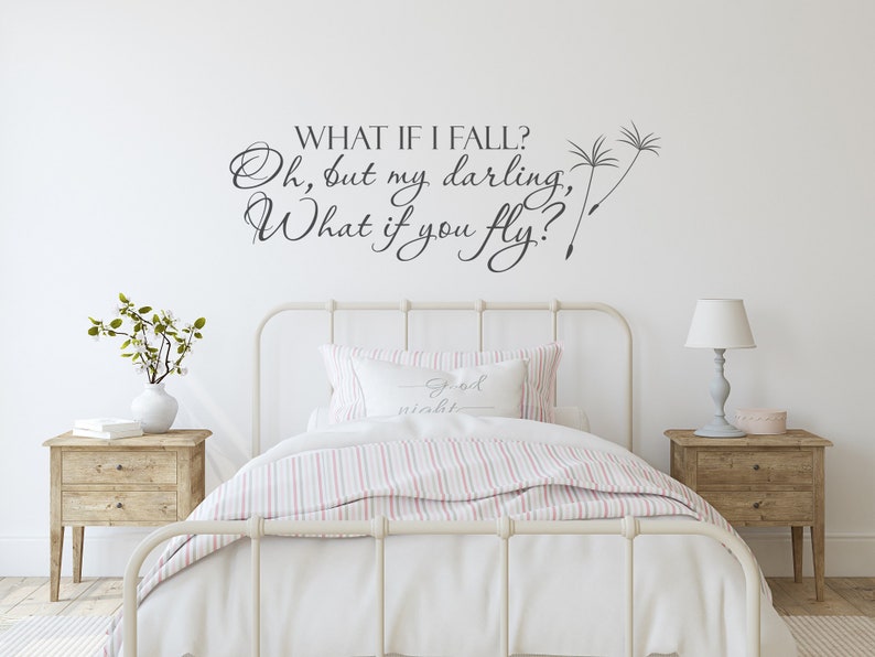 May include: White bedroom with a white bed frame and a white and pink striped comforter. The wall has a black vinyl decal with the text "WHAT IF I FALL? Oh, but my darling, What if you fly?" with two dandelion seed drawings.