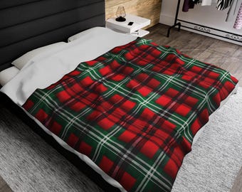 May include: Red, green, and white plaid throw blanket on a white bed with a black headboard.