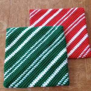 May include: Two crocheted pot holders, one green and white with diagonal stripes and one red and white with diagonal stripes.