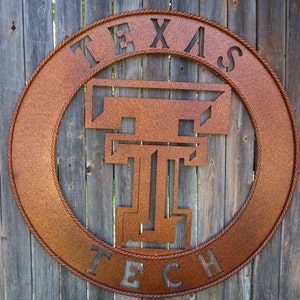 May include: A rusty brown metal sign with a rope border. The sign says "Texas Tech" in a stylized font with a large "T" in the center.