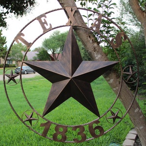 May include: A large metal Texas star with a rope design around the edge. The star is brown and has a rustic finish. The letters "TEXAS" are on the top of the star and the numbers "7836" are on the bottom.
