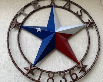 May include: A brown metal wreath with a red, white, and blue star in the center. The wreath has the word "TEXAS" and the year "1836" written on it.