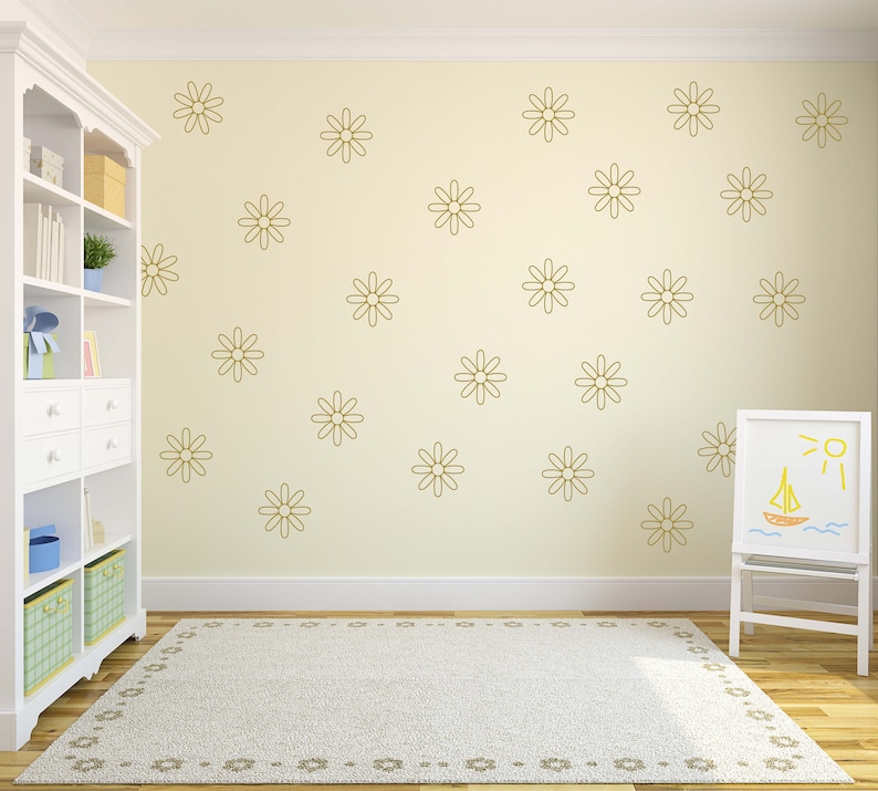 May include: A white bookshelf with a light wood top and a white rug with a floral pattern. The wall is a light yellow colour and has a pattern of gold daisy decals.
