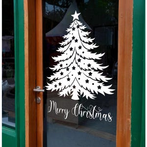 May include: A white vinyl sticker of a Christmas tree with stars on a glass door. The sticker says "Merry Christmas" in a cursive font.
