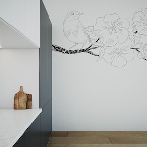 May include: A black and white line drawing of a bird perched on a branch with flowers. The drawing is on a white wall in a kitchen.