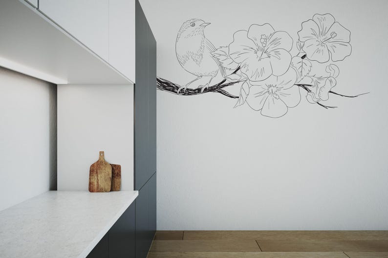 May include: A black and white line drawing of a bird perched on a branch with flowers. The drawing is on a white wall in a kitchen.