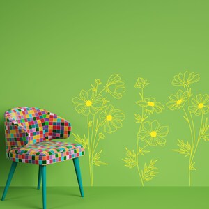 K&ouml;nnte beinhalten: Ein bunter Patchwork-Stuhl steht vor einer gr&uuml;nen Wand mit einem gelben Blumendesign. Das Design zeigt mehrere stilisierte Kosmosblumen.