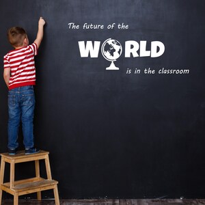 May include: A young boy stands on a wooden step stool and writes on a black chalkboard. The chalkboard says "The future of the WORLD is in the classroom" with a globe icon.