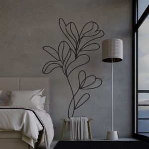 Op de afbeelding: Een slaapkamerinterieur met een bed, een kruk, een staande lamp en een zwart-witte abstracte bloemenmuursticker. De kamer heeft een groot raam met uitzicht op een bergketen.