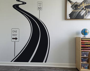 May include: A black and white wall decal of a winding road with a speed limit sign and a one-way sign. A framed picture of the Eiffel Tower and a globe are also visible.