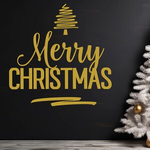 K&ouml;nnte beinhalten: Ein schwarzer Hintergrund mit einem goldenen, stilisierten Weihnachtsbaum und den Worten "Merry Christmas" in goldenen Buchstaben. Rechts im Bild steht ein wei&szlig;er, k&uuml;nstlicher Weihnachtsbaum mit goldenen Kugeln.