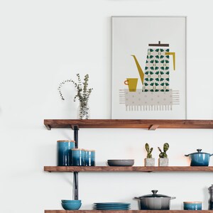 May include: A framed print of a stylised illustration of a green and yellow coffee pot with a cup on a white background. The print is hanging on a wall above a wooden shelf with blue ceramic canisters, a grey bowl, and a green cactus.
