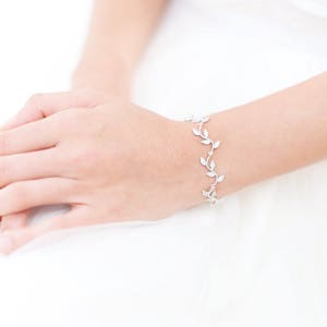 Peut inclure: Un bracelet argenté avec un délicat motif de feuilles. Le bracelet est composé de petites feuilles interconnectées qui créent un motif fluide et ressemblant à une vigne.