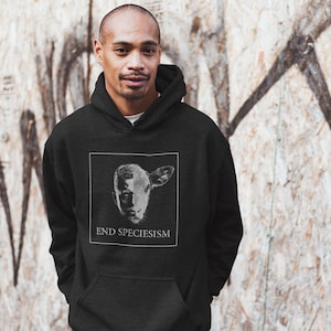 Op de afbeelding: Een zwart hoodie met een witte afbeelding van een schapenkop en de tekst "END SPECIESISM".