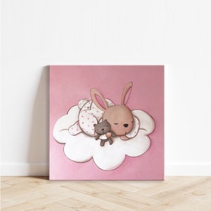 Puede incluir: Una ilustración rosa y blanca de un conejo marrón durmiendo en una nube con un pequeño oso de peluche marrón. El conejo lleva un pijama rosa con lunares blancos.