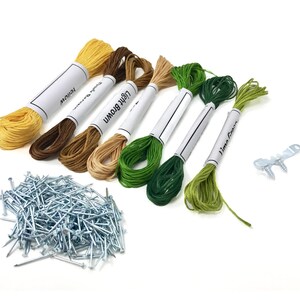 Pu&ograve; includere: Un set di sei bobine di filo da ricamo in giallo, marrone, marrone chiaro, verde e verde lime. Il filo &egrave; confezionato su etichette bianche con i nomi dei colori stampati su di esse. Il set include anche un sacchetto di puntine argentate e due viti argentate con una staffa in metallo.