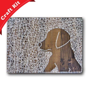 May include: A string art craft kit featuring a silhouette of a dog on a wooden background. The dog is outlined with white string wrapped around nails.