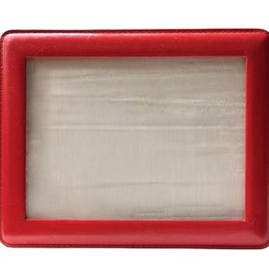 May include: A rectangular picture frame featuring a smooth, vibrant red border with visible stitching along the inner and outer edges. The center of the frame contains a light, off-white, textured insert with subtle horizontal lines.