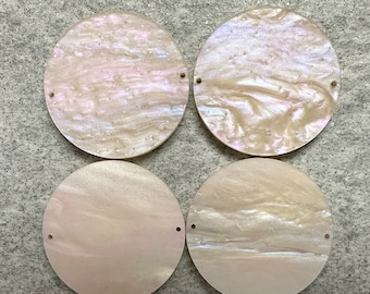 Könnte beinhalten: Vier runde, irisierende Perlen aus Perlmutt. Jede Perle hat einen perlmuttartigen Glanz mit Variationen in Rosa, Weiß und Creme. Die Perlen haben zwei kleine Löcher zum Auffädeln. Ideal für die Schmuckherstellung.
