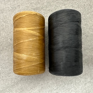 May include: Two spools of waxed thread, one brown and one black.