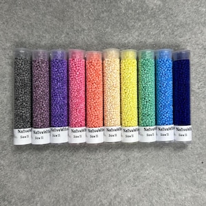 May include: Twelve small glass tubes filled with colorful seed beads. The tubes are labeled "Native Wild" and "Size 11".