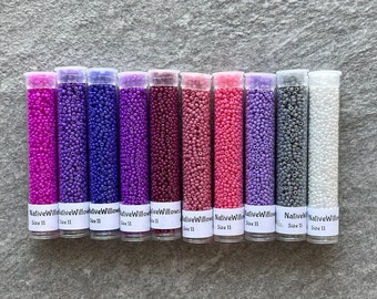 May include: Ten small tubes of seed beads in various shades of purple, pink, and gray. Each tube is labeled "Native Willow" and "Size 11".