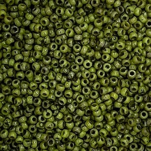 May include: A close-up image of a large quantity of small, round, green glass beads. The beads are opaque and have a slightly irregular shape.