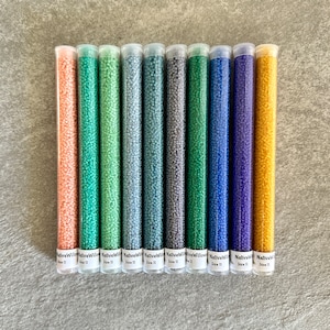 May include: Ten tubes of size 11 seed beads in various colors, including peach, green, gray, blue, and gold. The tubes are labeled "NativeWillow" and "Size 11".