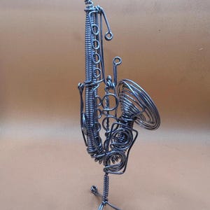 Saxophone stylisé en fil métallique, avec détails complexes et support stable.